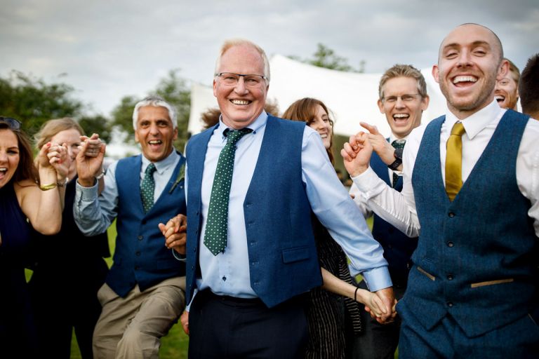 Guests laugh as they run towards camera during dancing