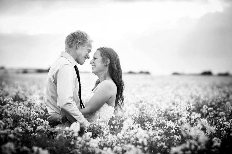 Couple laugh in a field of flowers