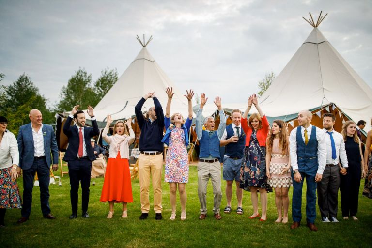 Guests start a Mexican wave while waiting for a ceilidh dance to start outside, tipi is behind them