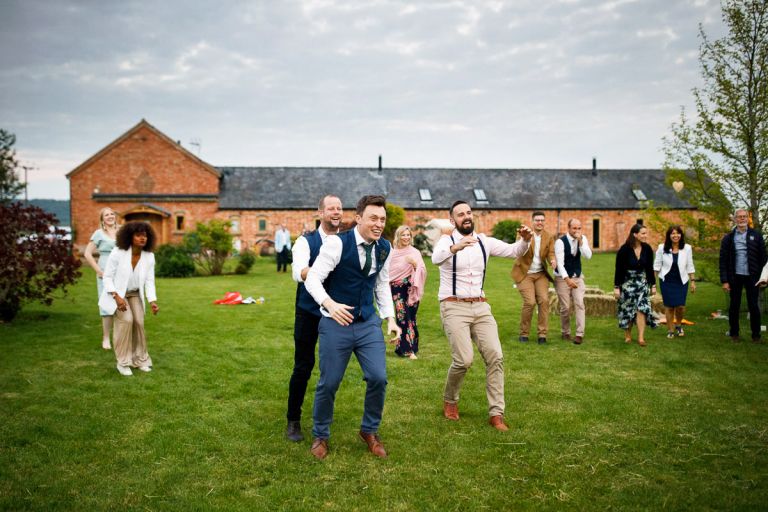 guests messing around during dance at outside wedding reception