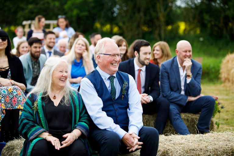 Parents sit and laugh together before the wedding ceremony starts