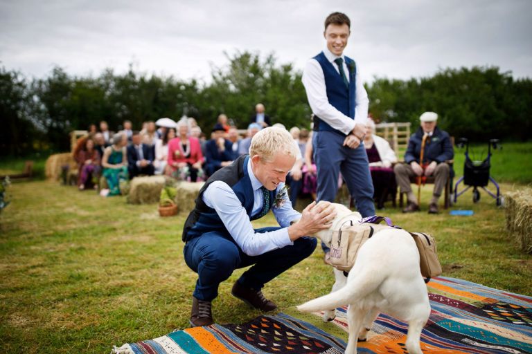 Groom welcomes his dog to the wedding ceremony - dogs at weddings are great!