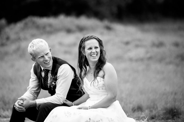 Close up of couple as they laugh during their outside wedding ceremony, 