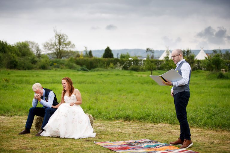 Couple laugh enthusiastically at what the celebrant MAD ceremonies is saying during their humanist wedding ceremony