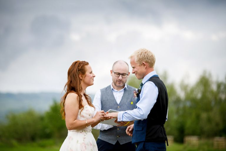 Bride puts ring on grooms hand during their humanist outside ceremony performed by MAD ceremonies