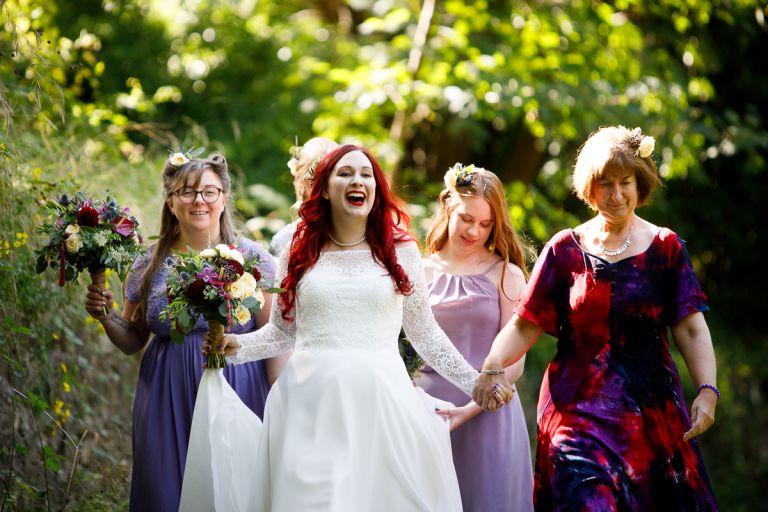 Bride laughs as she arrives to ceremony with mum and bridesmaids
