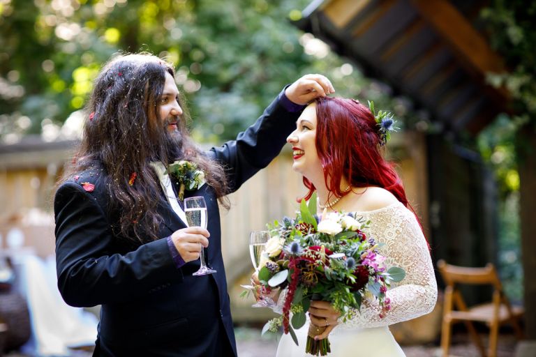 Grooms removes confetti from brides hair