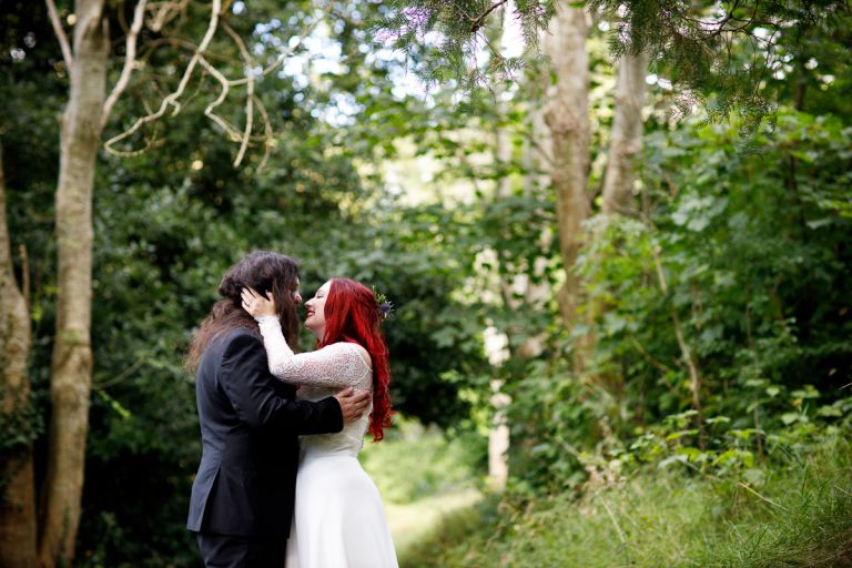 Couple kiss in the trees at their wedding