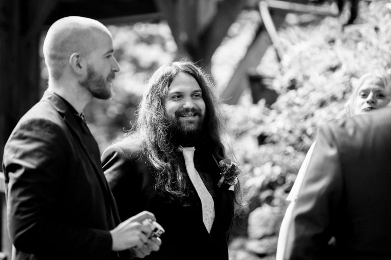 Groom laughing with friends at his wedding in arnos vale