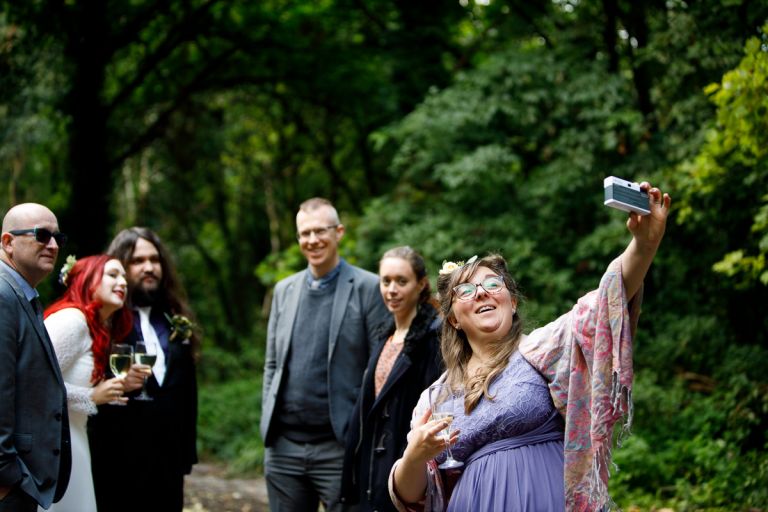 Bridesmaid takes photo of herself and guests with an old camera