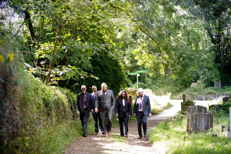 Groom walks with friends to forest setting in bristol