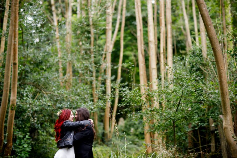 Couple hug in the trees at bristol forest wedding