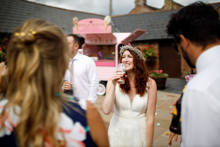 Bride smiles with pimms at Gloucester Barn wedding