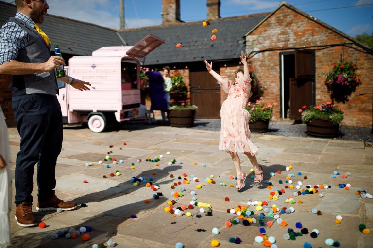 kids play with pompoms at wedding