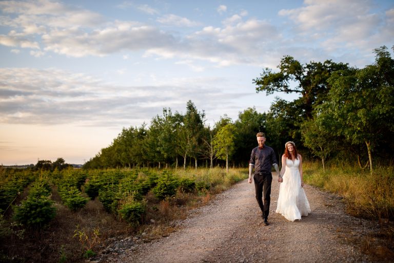 The Overbarn wedding photograph, couple walking through trees in evening light