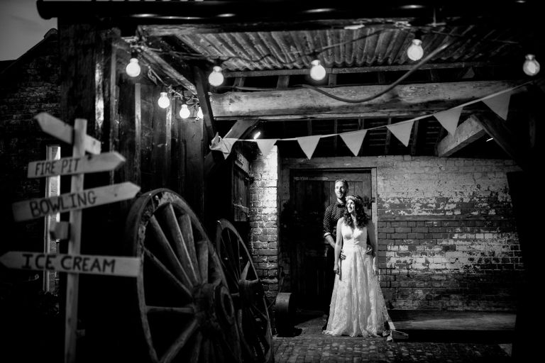 Rustic couple photo with festoons inside barn at The Over Barn in Gloucester