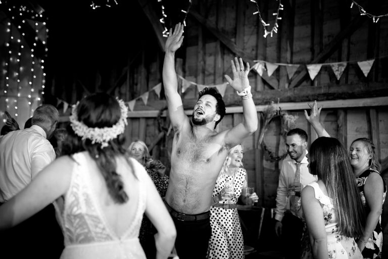 Guest rips off shirt at wedding at the over barn