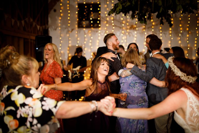 Guests join hands to dance at barn wedding in gloucester