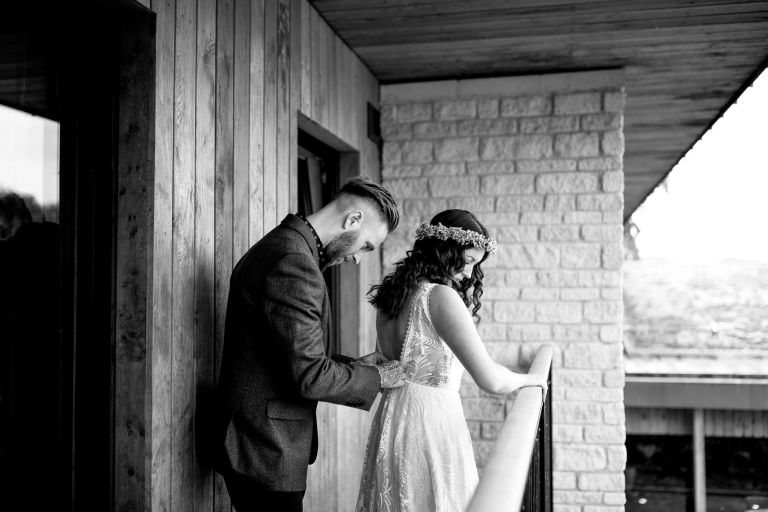 black and white photo of bride and groom getting ready together before their wedding at The Over Barn