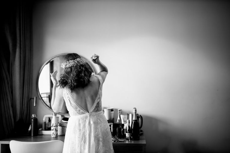 Bride sprays hair one more time before leaving for her wedding ceremony at The Over Barn