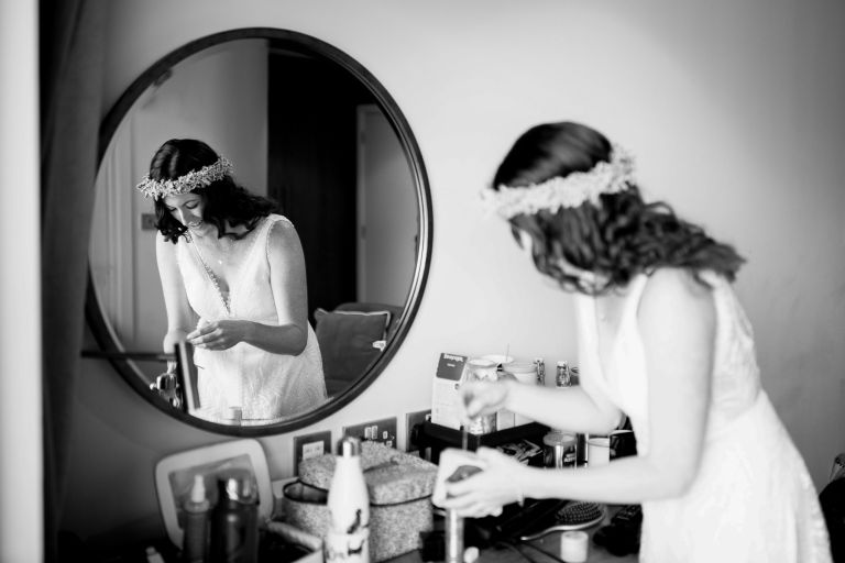 Bride and her reflection as she gathers her things to leave for her wedding ceremony