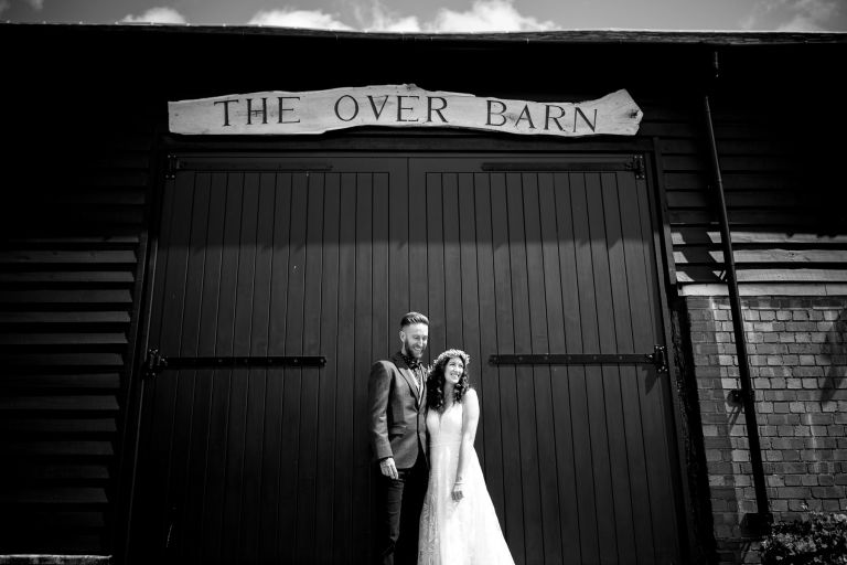Wedding couple in front of the barn doors of The Over Barn