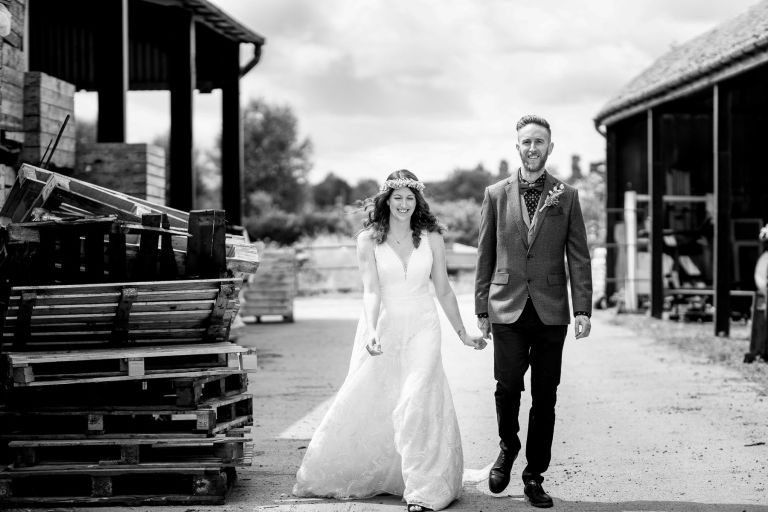 Couple walking towards camera smiling during their couple shoot at The Over Barn