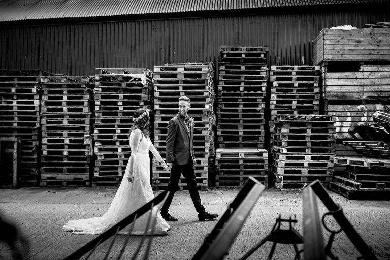 Couple walking in front of pallets at The Over Barn with farm equipment