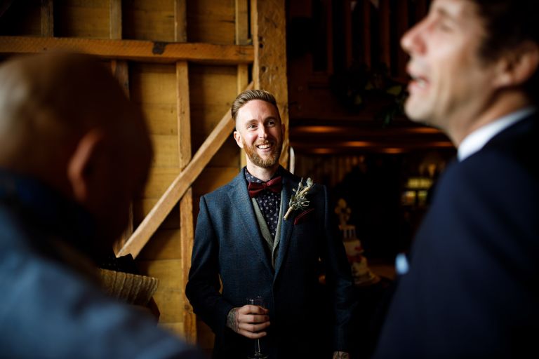 Groom spends time with guests before wedding ceremony at The Over Barn