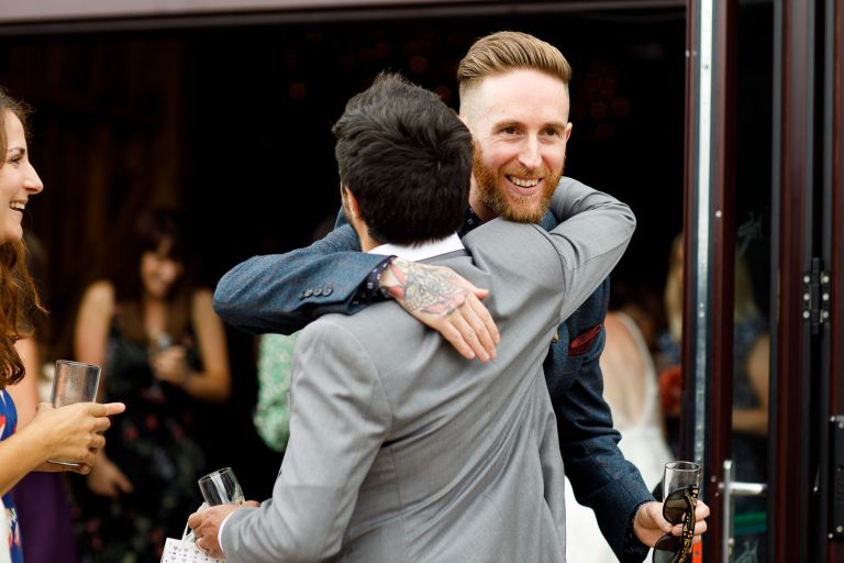 Groom hugs friend before wedding ceremony