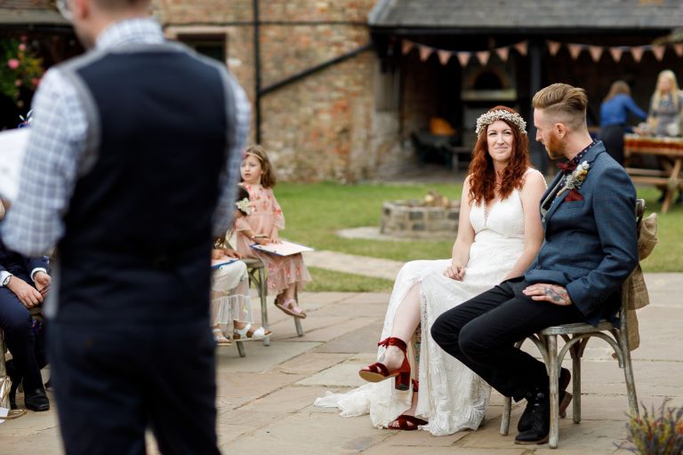 Couple look at each other during their outside humanist wedding at The Over Barn