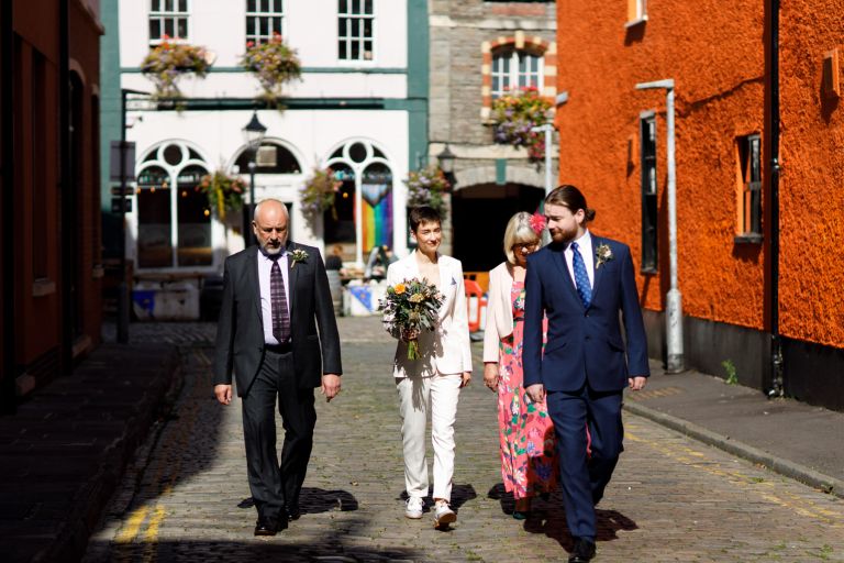 Bride walks with family to wedding in Bristol