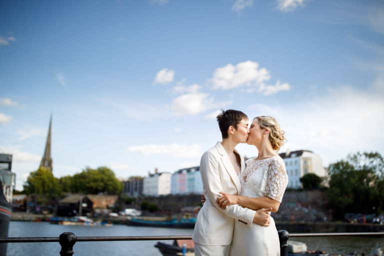 Brides kiss with Bristol colourful houses in the background