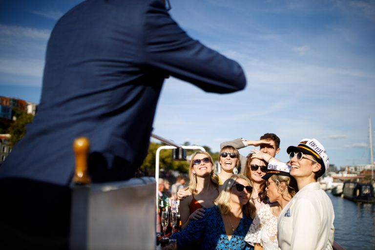 Guests smile for a photo on a boat in Bristol wedding